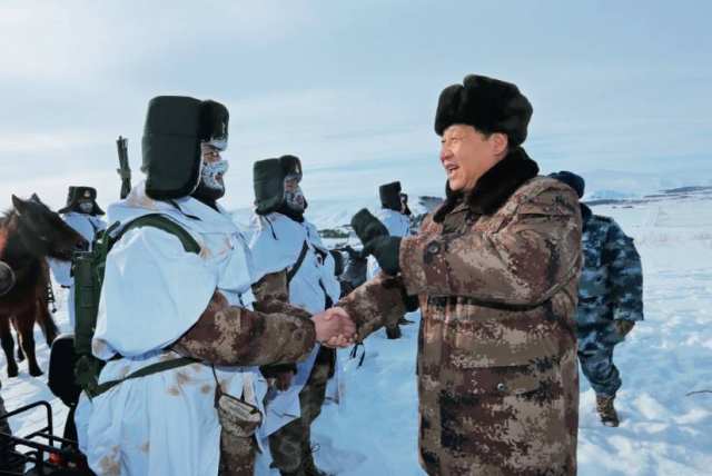 2014年1月26日，习近平来到内蒙古阿尔山，冒着零下 30多摄氏度的严寒，迎 风踏雪慰问在边防线上巡逻执勤的官兵    李刚摄/本刊
