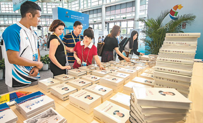 图为9月2日，采访金砖国家领导人厦门会晤的中外记者，在新闻中心阅读不同语种的《习近平谈治国理政》。本报记者 史家民摄